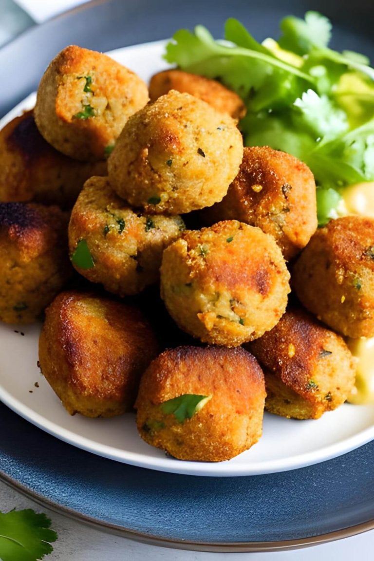 Vegan Chickpea Meatballs on a white and blue plate with greens in the background