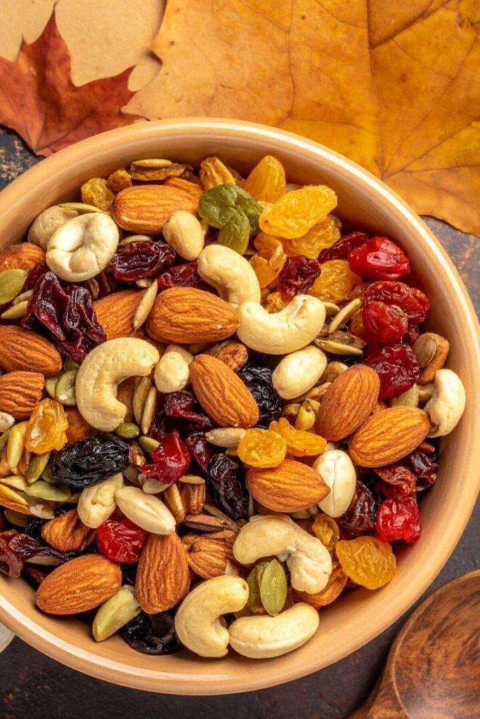 Bowl of trail mix with fall leaves in the background