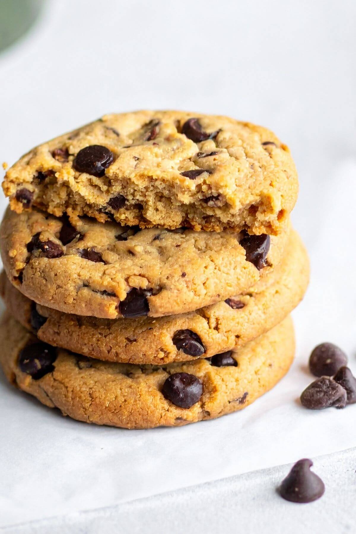 Stack of Vegan Chocolate Chip Cookies with a half of a cookie on top