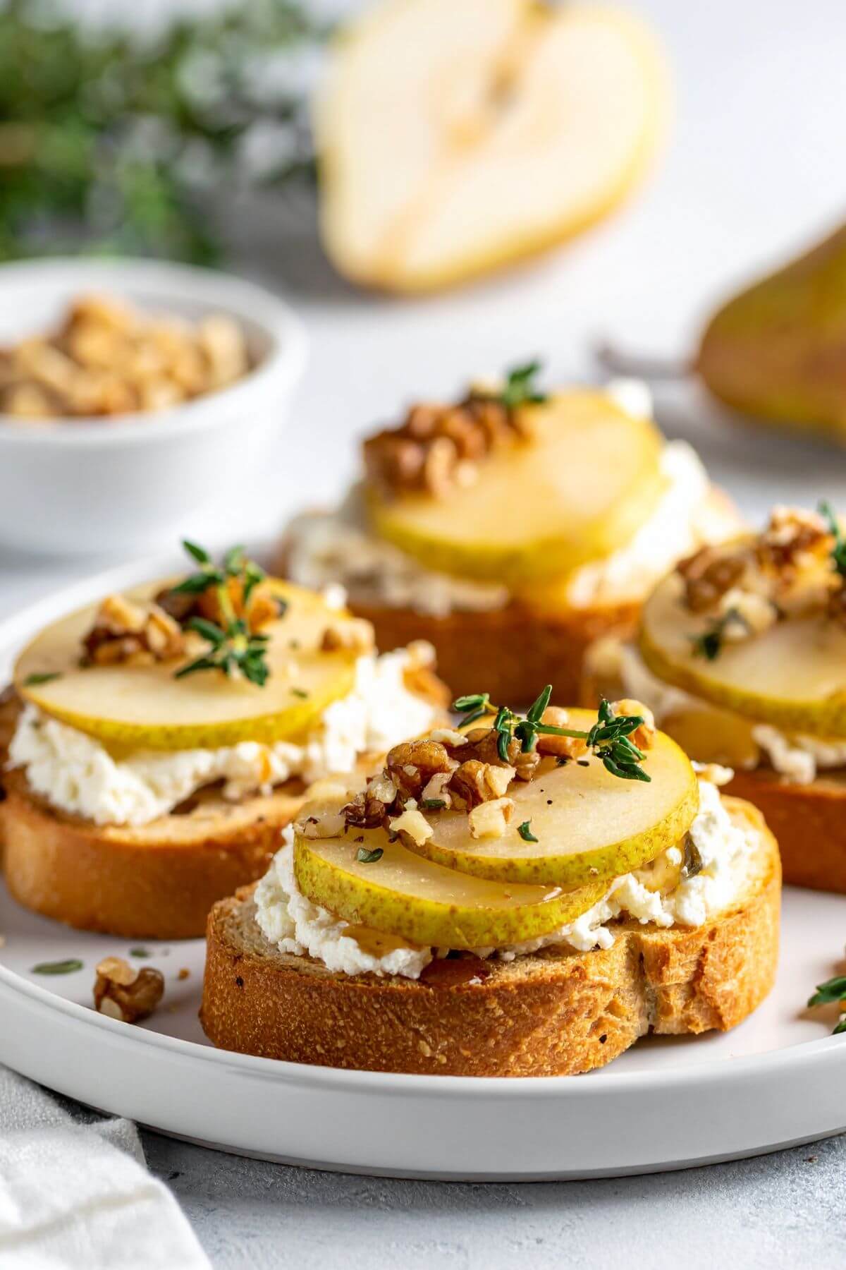 Pear, Walnut, Feta Crostini with maple and Thyme on a plate