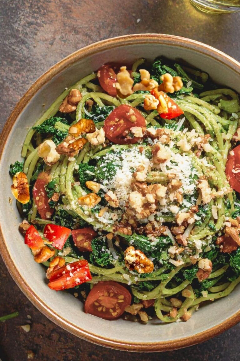 Dish of delicious Kale and Walnt pasta with tomatoes and vegan cheese