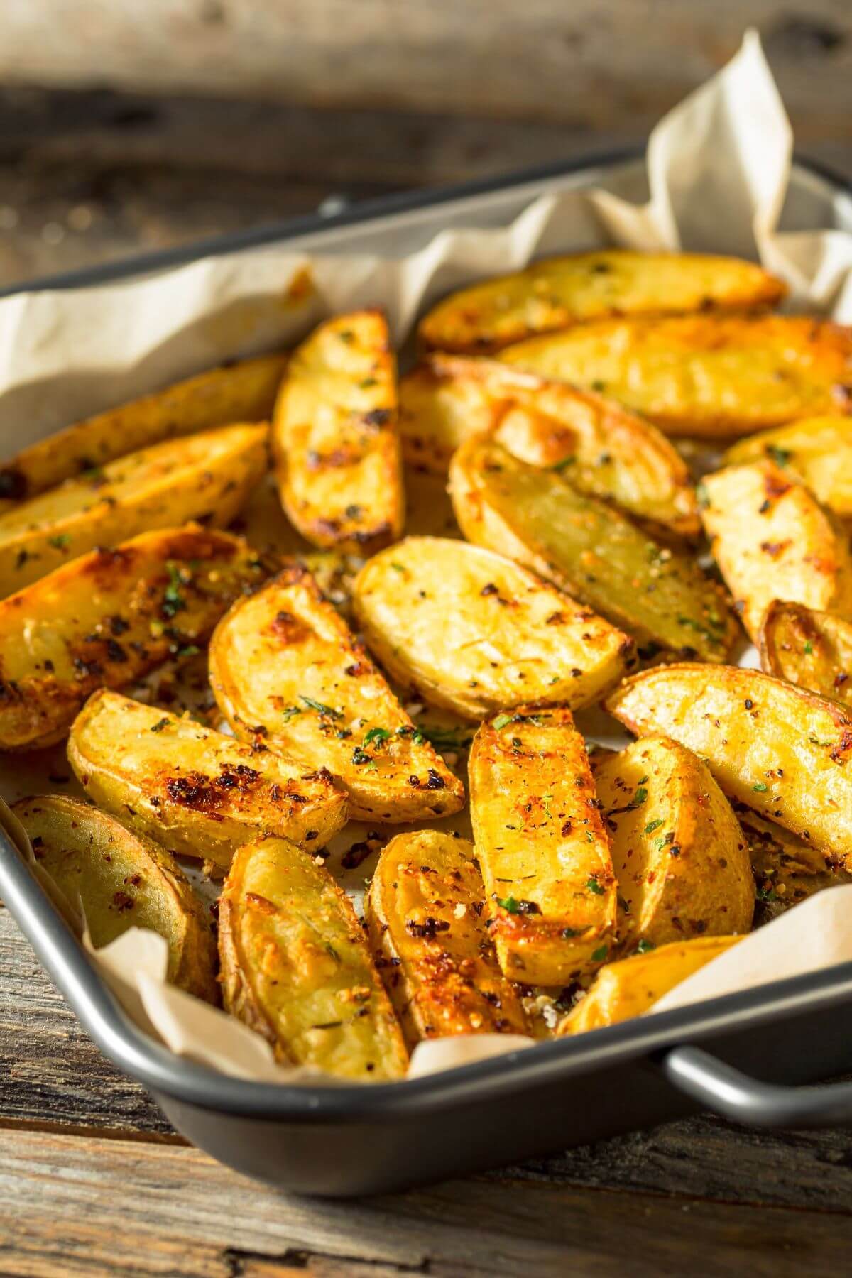 Easy Potato Wedges in a baking pan on parchment paper