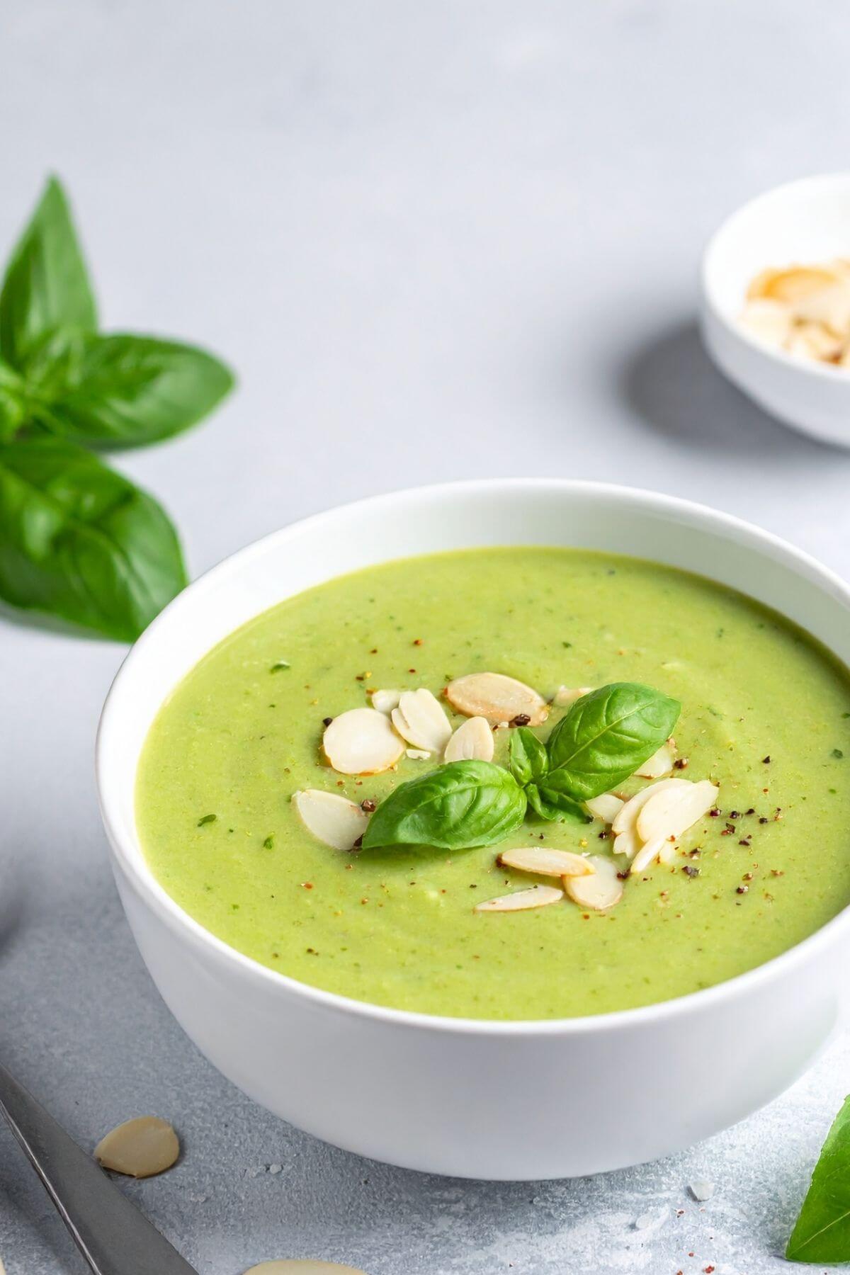 Bowl of vegan Zucchini Soup with Lemon and Basil garnished with sliced almonds and basil
