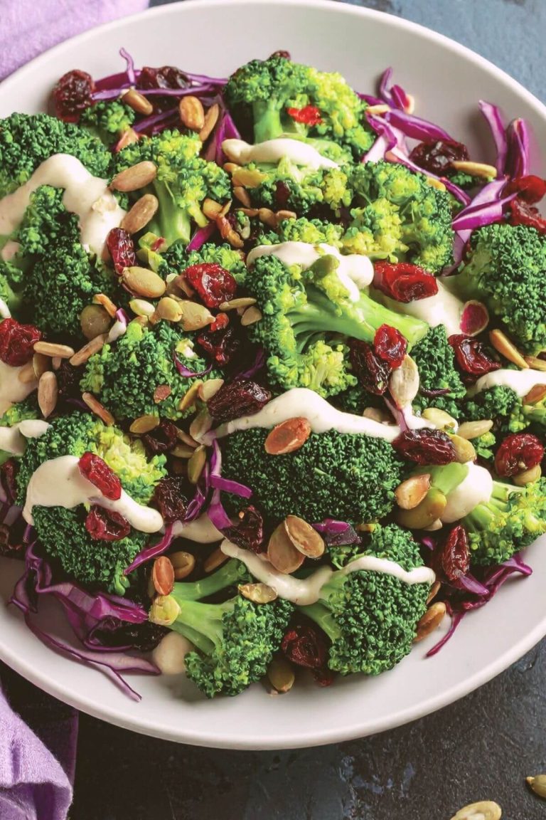 Dish of vegan Broccoli Salad with broccoli, dried cranberry, seeds, almonds and mayo dressing