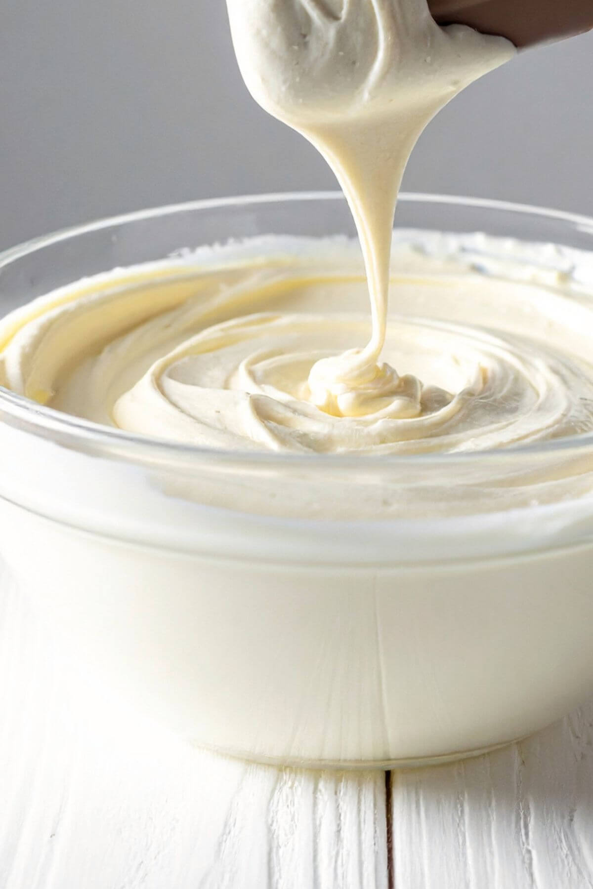creamy vegan cream cheese frosting dripping from spatula