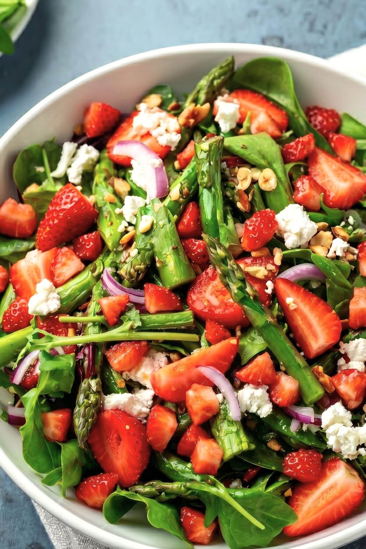 fresh strawberries and asparagus salad with greens and red onion