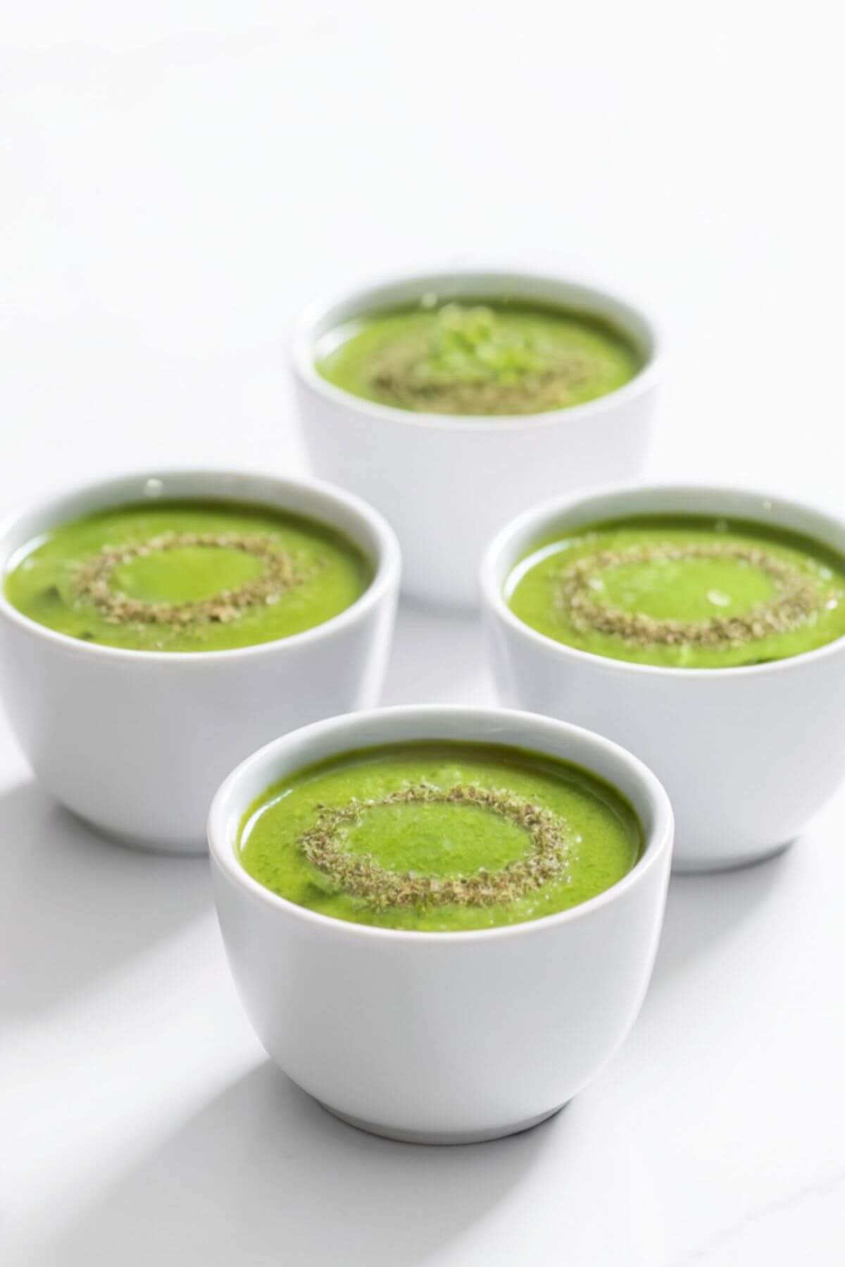 Broccoli Soup served in small ceramic cups. Step one with crushed seeds
